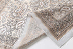 Folded edge close-up: apricot paisley border band above the narrow rolled hem
