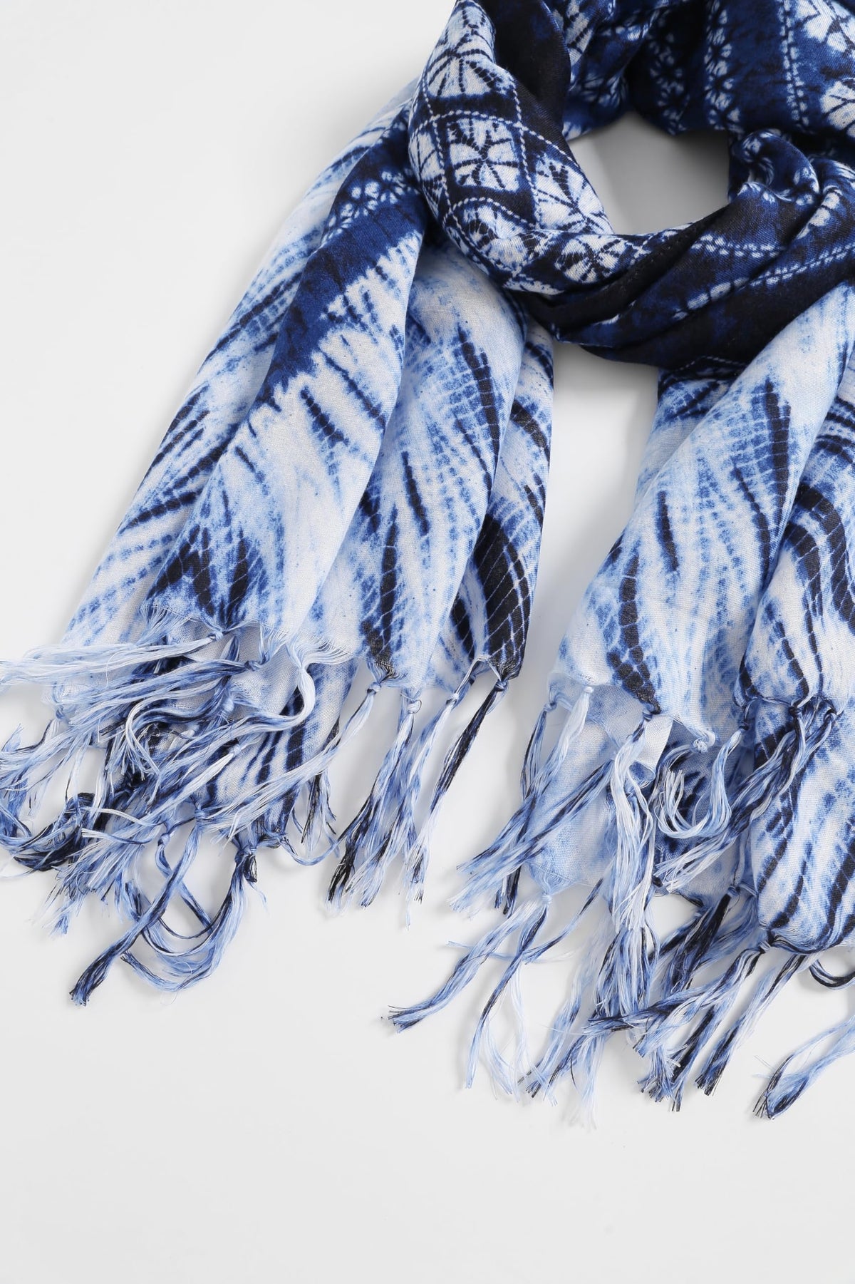 Jeelow indigo batik scarf hanging with both fringed ends together, showing the feathered shibori rays below the navy medallion band