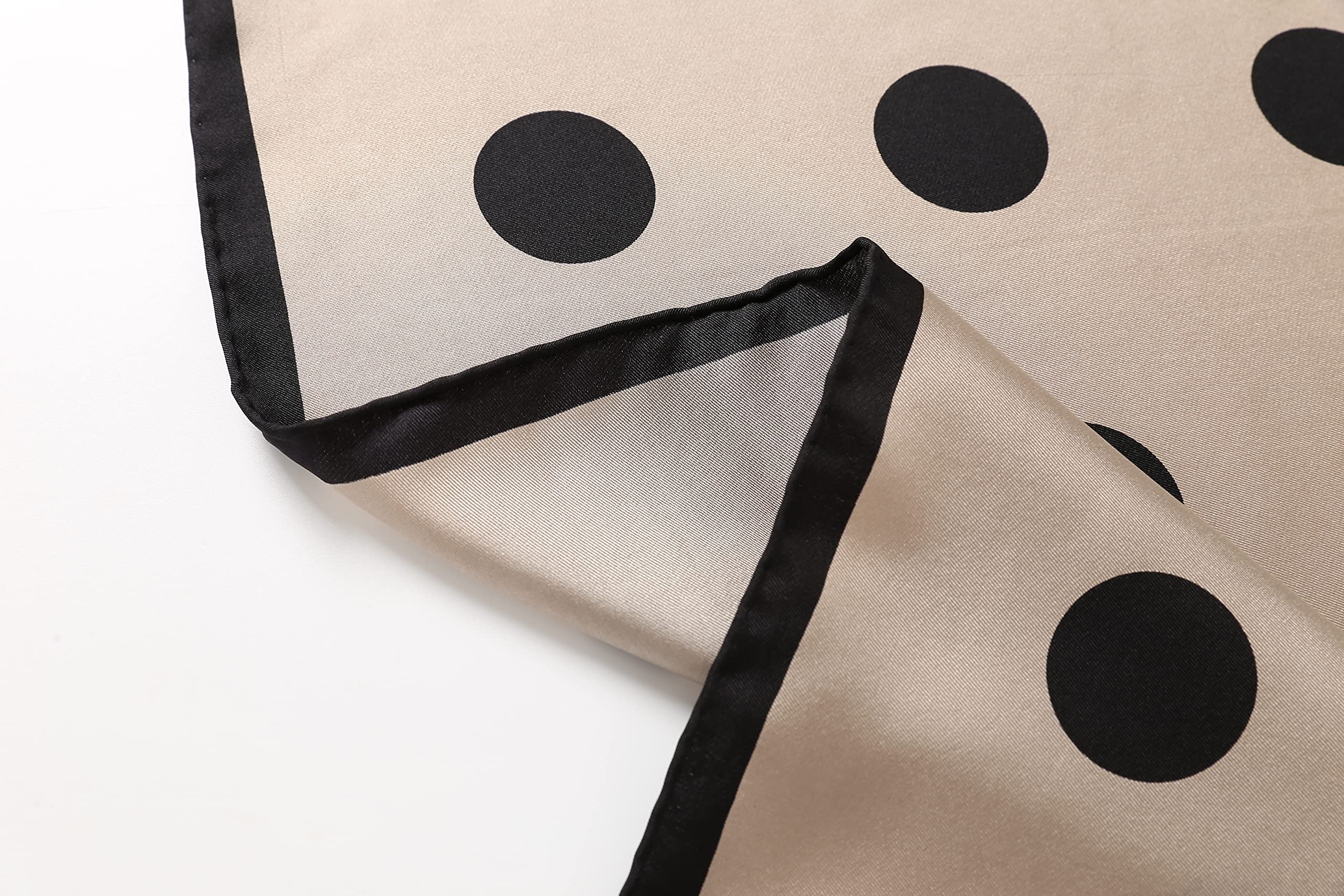 Detail of the greige square's black border and narrow hand rolled hem at the corner