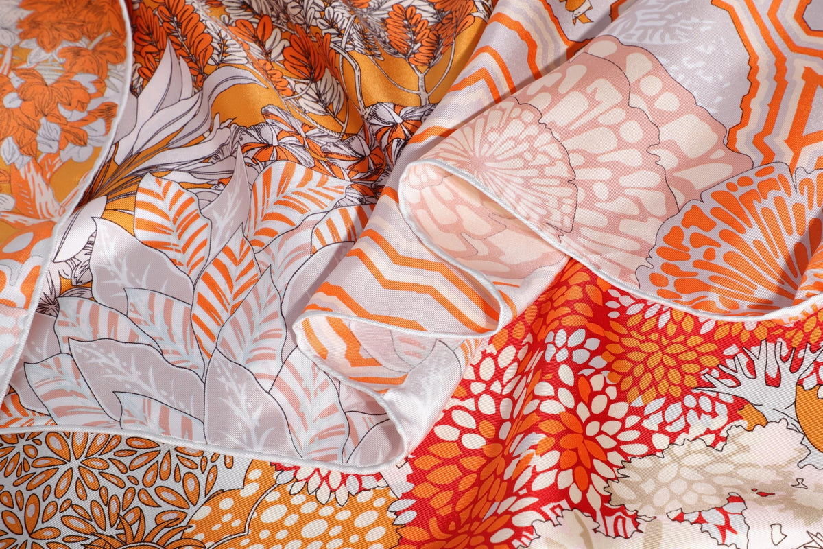 Close up of the coral and orange rainforest print on mulberry silk twill