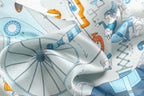Soft folds of pale blue silk over the big spoked wheel and an orange balloon