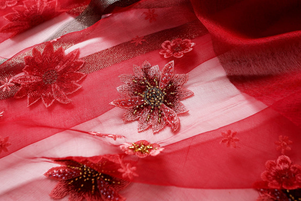 Close up of beaded red flowers stitched onto the sheer panel