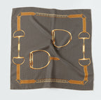 Flat view of the brown houndstooth silk square showing the gold chain and stirrup border