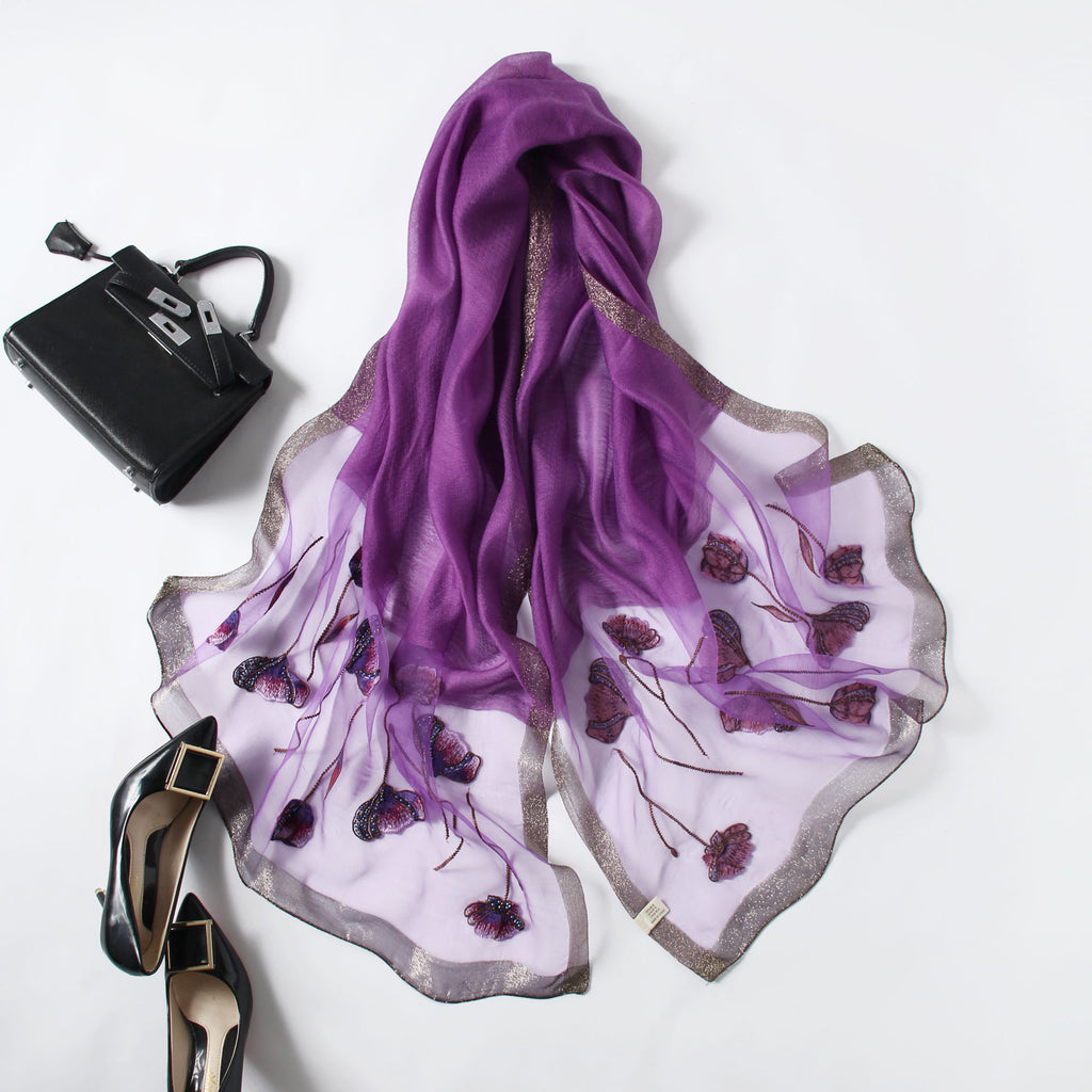 Close-up of embroidered poppies with beaded centers on mauve scarf