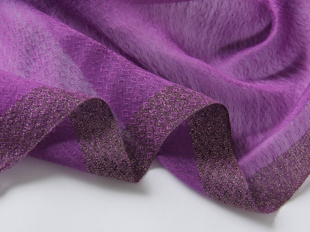 Close-up of embroidered poppies with beaded centers on deep purple scarf