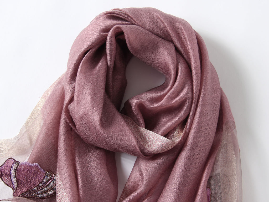 Close-up of embroidered poppies with beaded centers on mauve scarf