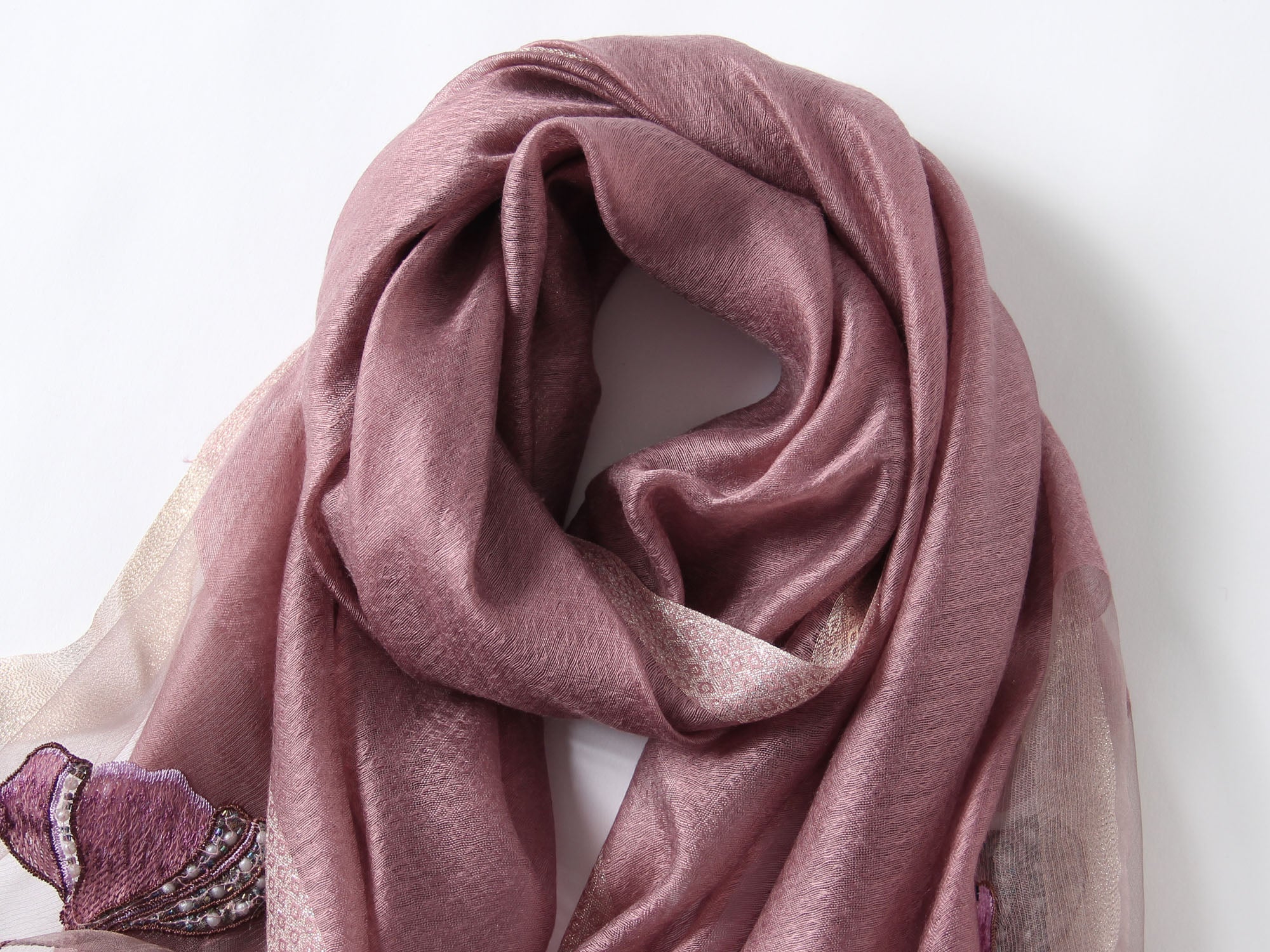 Close-up of embroidered poppies with beaded centers on mauve scarf