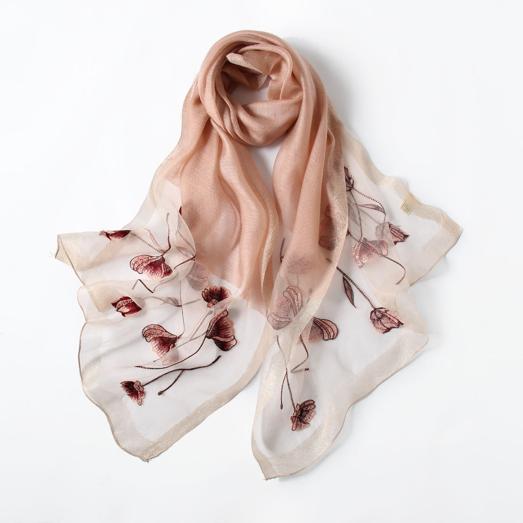 Close-up of embroidered poppies with beaded centers on gray scarf