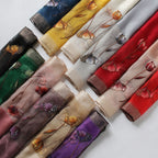 Close-up of embroidered poppies with beaded centers on gray scarf